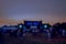 Unfocused outdoor festival music event projectors illumination and glares of light colorful concept in twilight phantom blue eveni