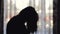 Unfocused Silhouette of young depressed woman near the window. Blurred background