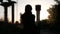 An unfocused silhouette of a young woman, walking away into the sunset