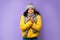 Unhappy African Lady Freezing Wearing Winter Clothes Over Purple Background