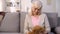 Unhappy aged lady looking at teddy bear toy missing family, feeling lonely