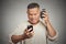 Unhappy angry middle aged man with alarm clock looking at smart phone