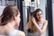 Unhappy beautiful young woman brushing her long dry tangled hair