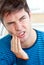Unhappy caucasian man having a toothache at home