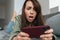 Unhappy caucasian woman playing online game on cellphone
