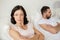 Unhappy couple having conflict in bed at home
