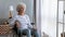 Unhappy disabled older woman sitting in wheelchair, feeling lonely