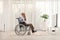 Unhappy elderly man in a wheelchair sitting at home