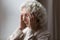 Unhappy elderly senior woman suffering from strong headache.