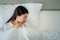 Unhappy exhausted woman closed eyes lying in bed cause of Headache, sore throat and tired, Concept of recuperation from illness,