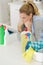 unhappy female cleaner with cloth and spray bottle tired