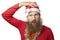 Unhappy funny santa claus with real beard and red hat and shirt looking at camera with sadness. isolated on white