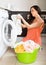 Unhappy girl using washing machine at home