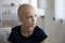 Unhappy hairless female cancer patient thinking at home