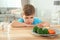 Unhappy little boy refusing to eat vegetables at table