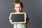 Unhappy little child showing empty writing slate to express reflection