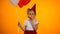 Unhappy lonely girl blowing party horn and holding balloons celebrating birthday