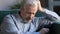 Unhappy lonely grey haired mature man sitting alone horizontal banner