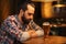 Unhappy lonely man drinking beer at bar or pub