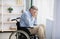 Unhappy and lonely senior handicapped man in wheelchair crying at home