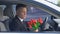 Unhappy man looking at bunch of tulips and deciding to drive away, breakup