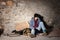 Unhappy man sitting on the floor with alms basket