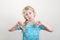 Unhappy preschool child kid showing dislike sign thumb fingers down. Portrait of little sad upset blonde Caucasian girl on light