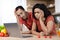 Unhappy sad young african american couple in same t-shirts look at laptop, find mistake in kitchen interior