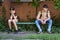 Unhappy schoolchildren a boy and a teenage girl are sitting on a bench outside the school building