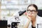 Unhappy Scientist Looking through a Microscope in a Laboratory