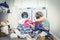 Unhappy Stressed Woman with Pile Of Clothes Near Washing Machine in laundry room, blue tone