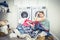 Unhappy Stressed Woman with Pile Of Clothes Near Washing Machine in laundry room, blue tone