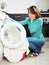 Unhappy woman cheking clothes near washing machine