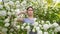 Unhappy woman with a clothespin on her nose on a walk in a blooming park.