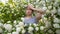 Unhappy woman with a clothespin on her nose on a walk in a blooming park.