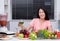 Unhappy woman drinking vegetable juice in kitchen