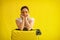 Unhappy woman in sunglasses hugs a suitcase on a yellow background. An upset girl missed her flight on a plane