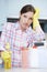 Unhappy Woman Surrounded By Cleaning Products At Home