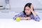 Unhappy women feeling dislike while looking at green apple on white table in kitchen