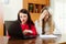 Unhappy women looking documents with laptop