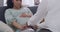 An unhappy worried pregnant female rubbing her belly while being comforted and consoled by her therapist during an