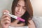 Unhappy young asian woman holding pregnancy test showing a positive result, Wellness and healthy concept, Abortion problem,