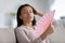 Unhealthy biracial woman breathe fresh air from hand fan