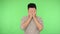 Unhealthy brunette man with bristle in shirt rubbing temples, head and grimacing from pain. studio shot, green background