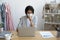 Unhealthy businesswoman in mask seated at desk and coughing
