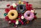 Unhealthy but delicious group of sweet sugar donut cakes and lots of gummy candies on vintage wooden table