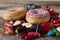 Unhealthy but delicious group of sweet sugar donut cakes and lots of gummy candies on vintage wooden table
