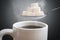 Unhealthy eating concept. Many sugar cubes above hot cup of tea or coffee