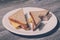 Unhealthy fast junk eating dieitng tasty homemade sandwich. Close up of tasty bitten cheese sandwich on a round plate. Wooden back