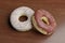 Unhealthy but tempting sugary dessert - two yummy and delicious donuts with colored sprinkles on shinny wood table in calories and